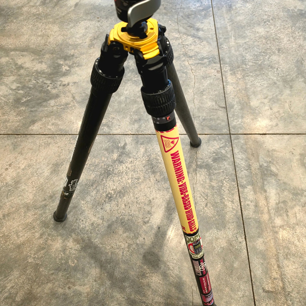 PRS shooting tripod with vibe-based wind calls sticker applied on leg, showing real-world use on shooting gear